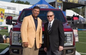 Mark LaNeve and Anthony Munoz in front of a Ford tailgating truck