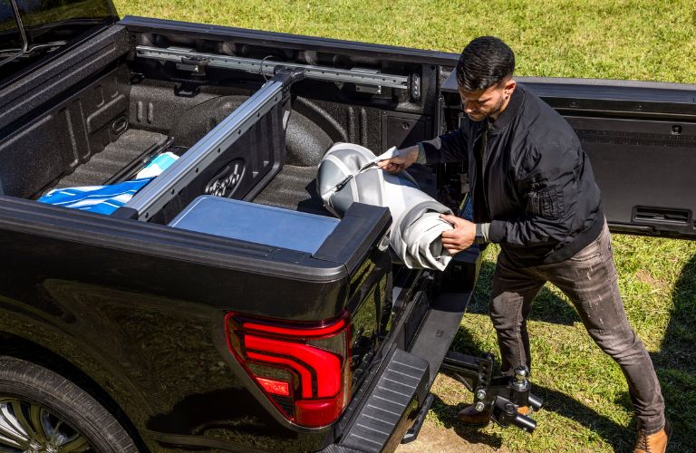 Man Loading Cargo in 2024 Ford F-150 with Pro Access Tailgate