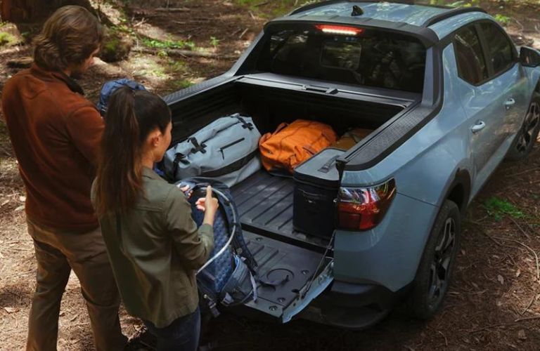 Couple Loading Camping Gear in Bed of 2024 Hyundai Santa Cruz