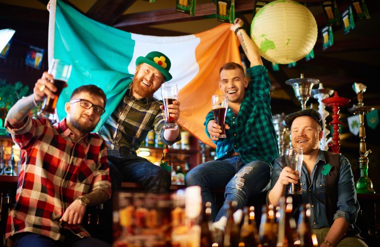 Group of Guys in a Pub with Beers and Irish Flag