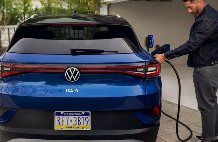 Man Plugging in a Blue 2024 Volkswagen ID.4